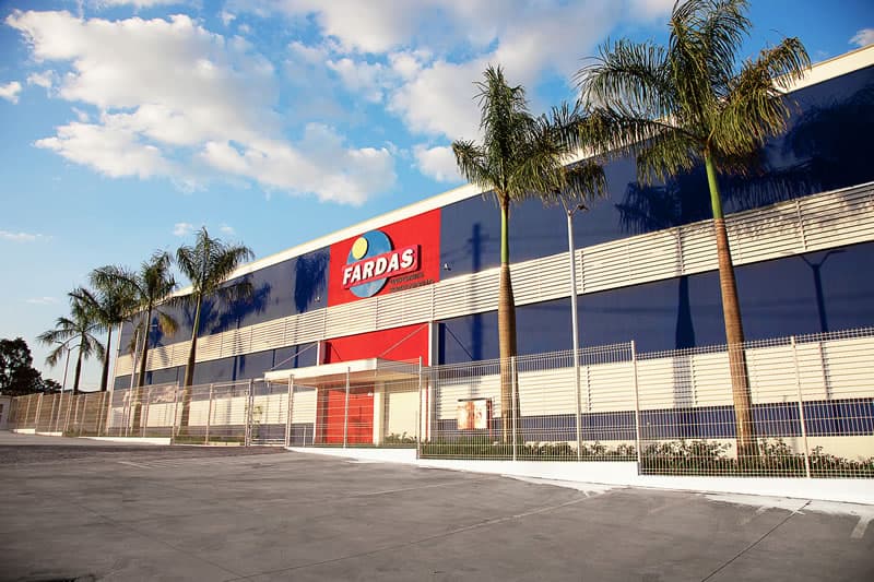 Exterior view of the Fardas manufacturing plant, a large industrial facility with the Fardas logo on the façade.